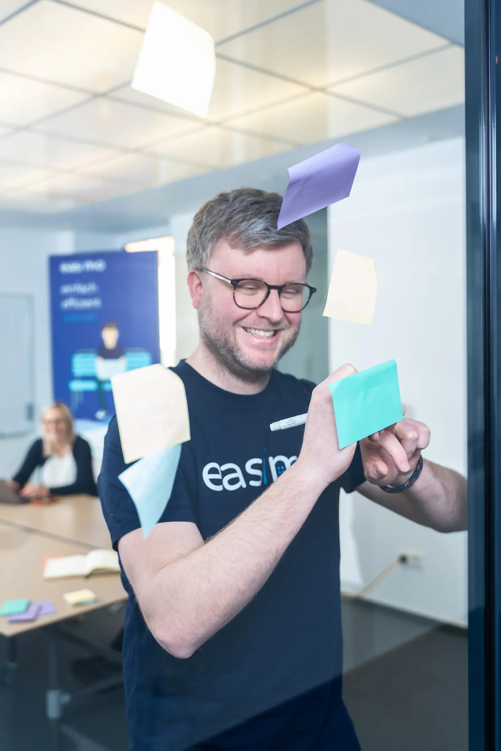 Mitarbeiter von easimo arbeitet mit Haftnotizen im Büro an Ideen für die Cloud-Software zur Immobilienverwaltung.